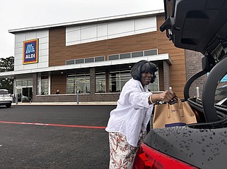 Barbra Scott loads her Aldi grocery bag into the trunk of her car Wednesday, April 24, 2024. Scott was there bright and early, eagerly waiting for the doors to open at the new grocery store at 2315 Richmond Road in Texarkana, Texas.  "I think it's going to be a great asset because the prices are so competitive and they use their brands to hold down the cost of items,” Scott said. (Staff photo by Sharda James)